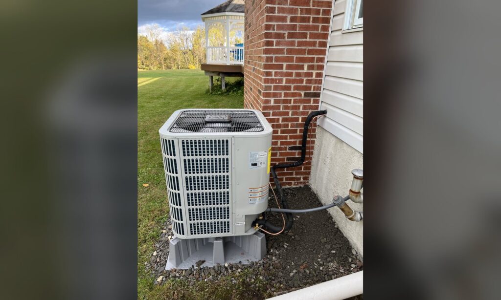 Outdoor heat pump condenser installed beside a Lehigh Valley home by Unity Heating & Air Conditioning